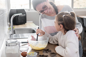Mother and daughter preparing Christmas cookie dough together at home, a Person Photo by etorres69