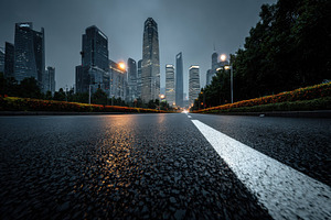 Wet city road leading to skyscrapers, a Photo by Pixeness Studio