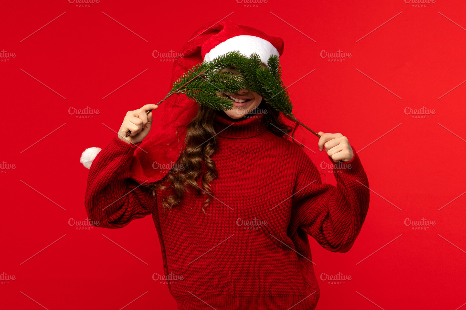 Girl in Santa hat holding fir branch, a Holiday Photo by Elena Vagengeim