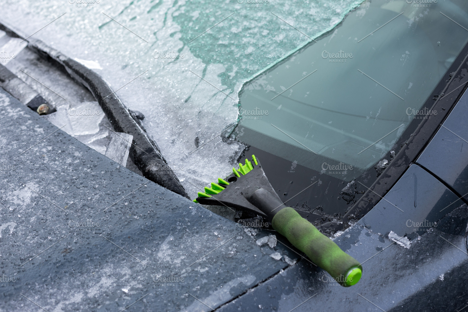 Close up of a car windshield being scraped to remove ice, with a, a Transportation Photo by Ales Munt