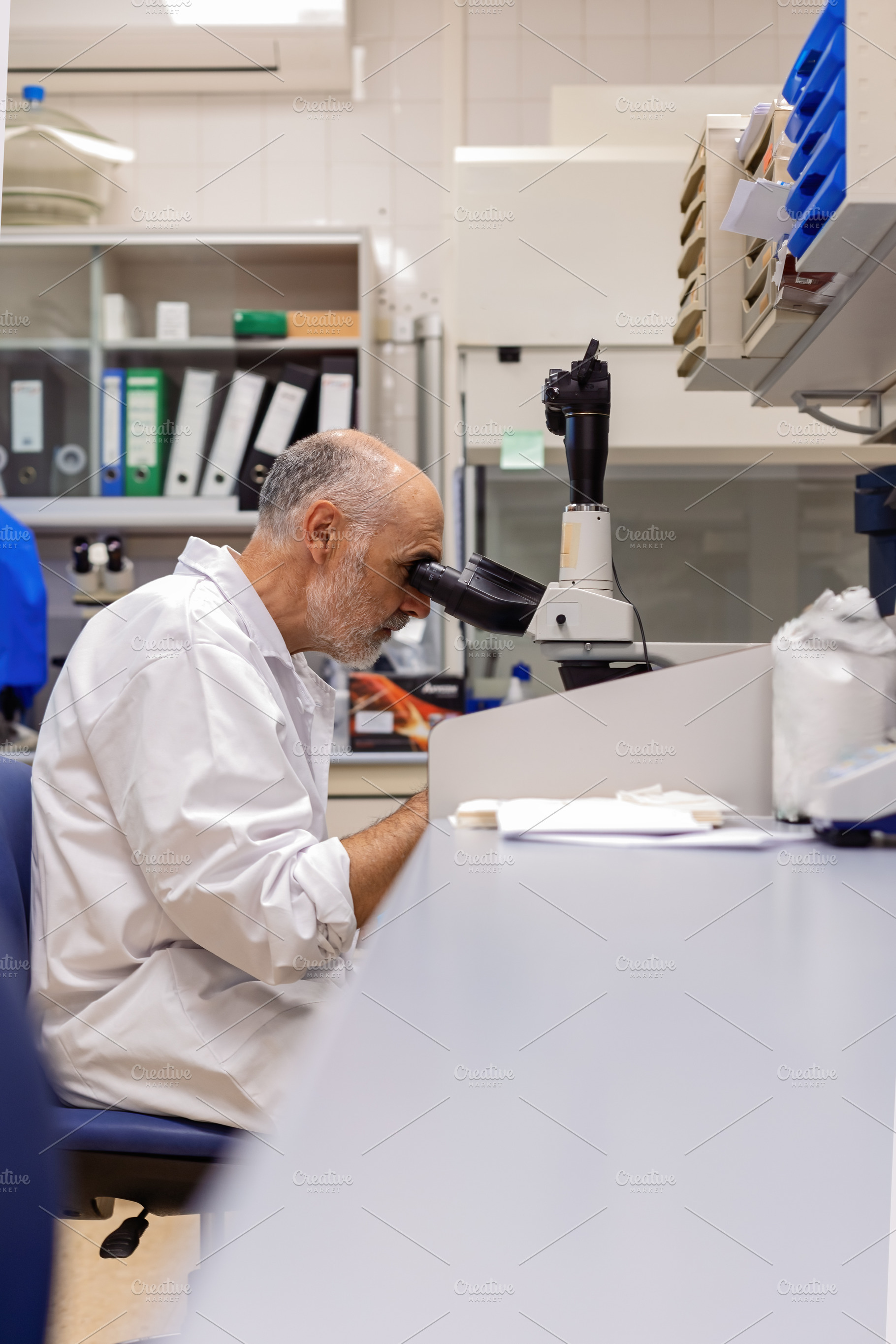 Researcher in a laboratory observing, a Health & Medical Photo by Perpis