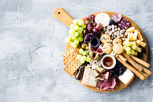 Assortment of tasty appetizers or containing charcuterie, cheese, and platter