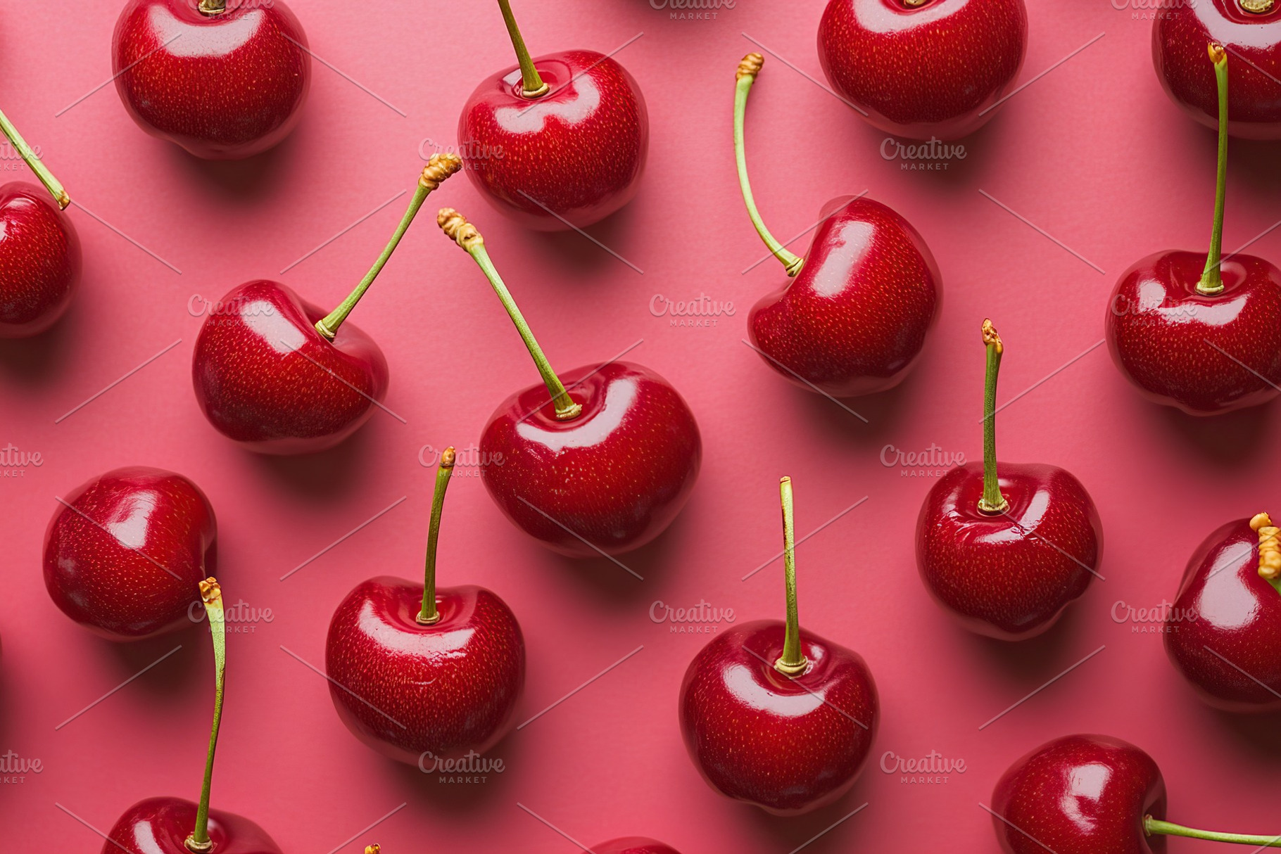 Vibrant red cherries on a pink background highlight their glossy texture, a Food & Drink Photo by AlyaAnd