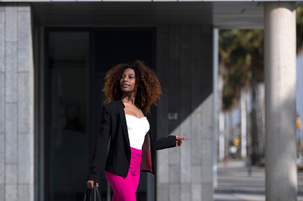 African American woman with handbag posing in the street, a Person Photo by RF Images