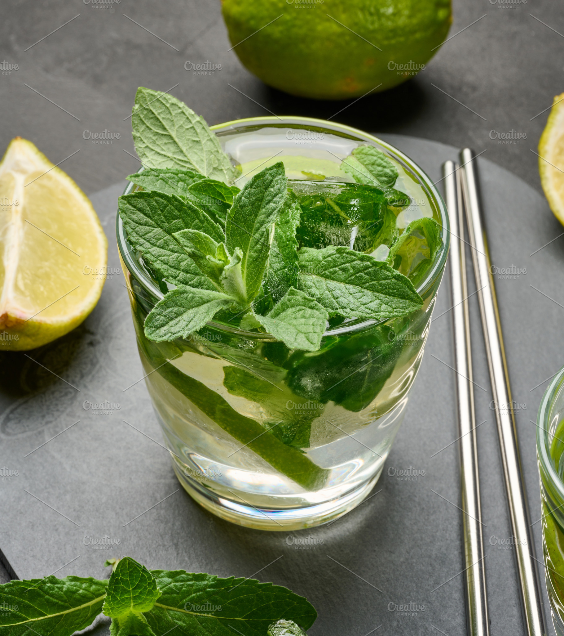 Glass of mojito cocktail with fresh mint leaves, lime slices, an, a Food & Drink Photo by ndanko