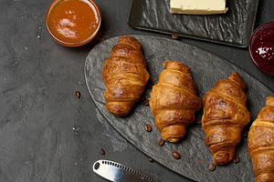 Freshly baked croissants on a black table, delicious breakfast, a Food & Drink Photo by ndanko