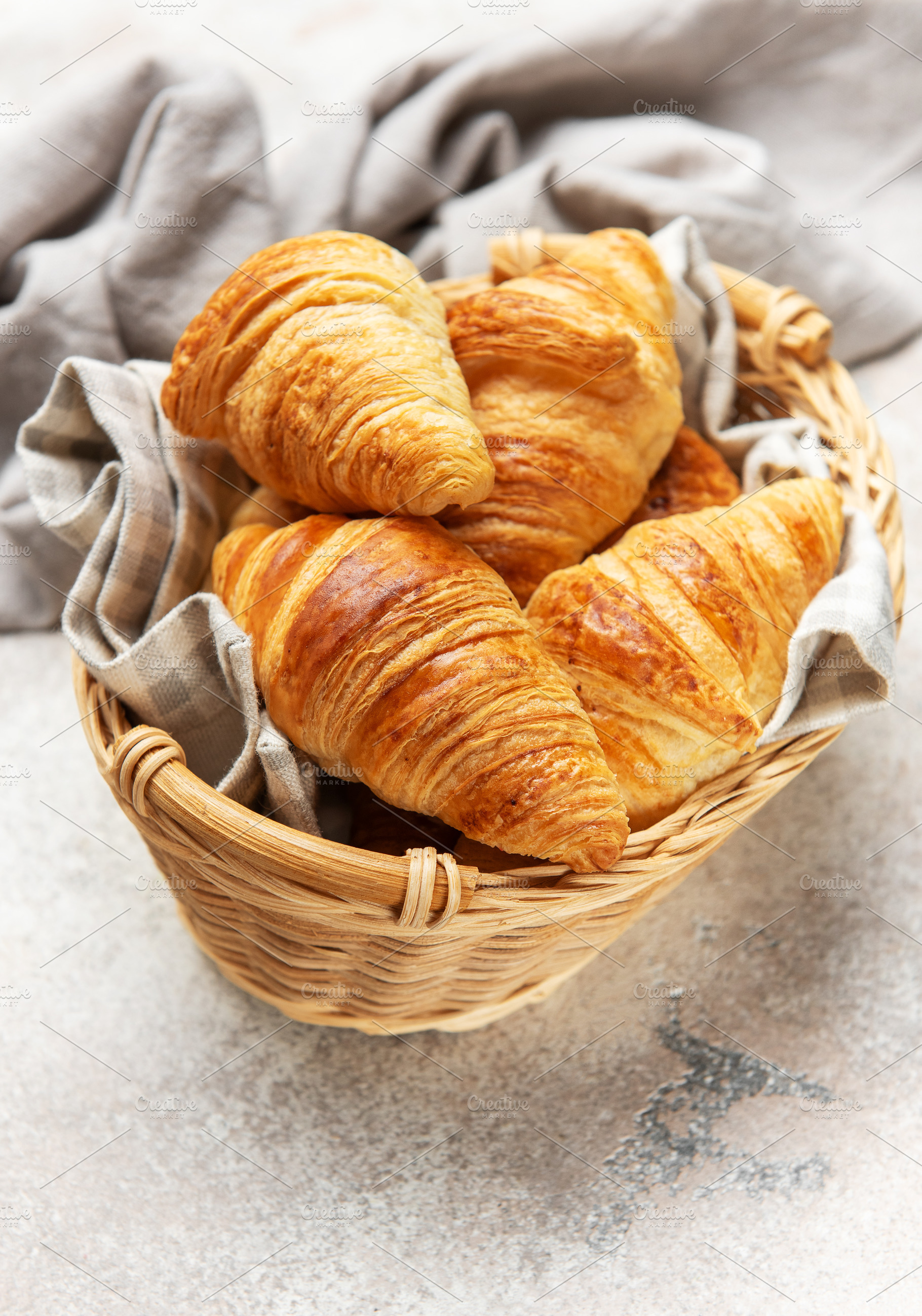 Golden brown croissants sit in a wicker basket, ready to be enjo, a Food & Drink Photo by Olena Rudo
