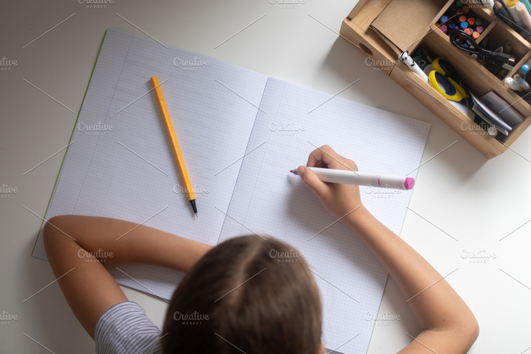 Smiling schoolgirl reading a notebook while studying at home, a Person Photo by etorres69