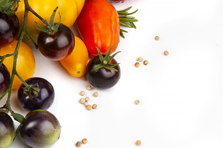 Assorted tomatoes and vegetables isolated on white background. P