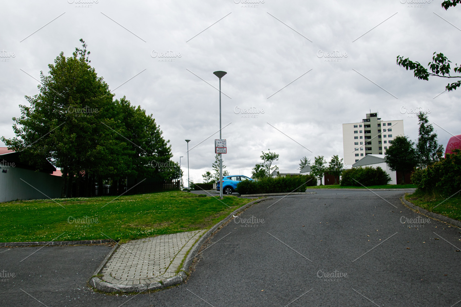 Urban landscape view in Reykjavik with trees, road, and high-rise building, a Photo by AS photostudio