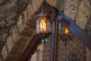 Ancient forged lantern on a stone wall in Baku with copy space, a Photo by Pictures for you!!!!!!!!!