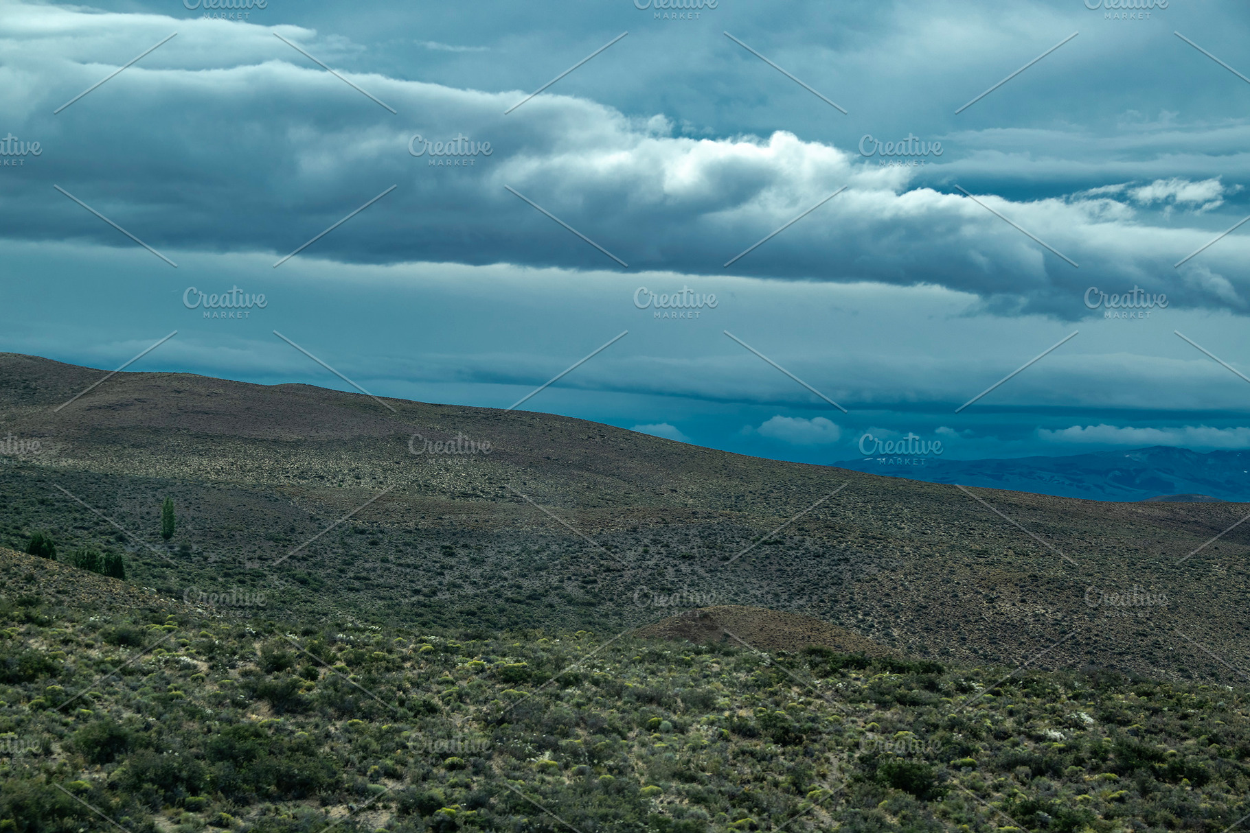 Mountains covered by big clouds at top, chubut province, argenti, a Photo by DanFLCreativo