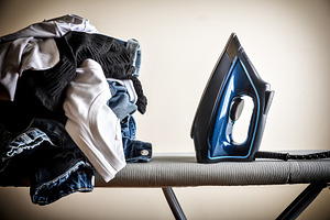 Hard work of ironing with board and pile of clothes, a Technology Photo by Davizro's Market