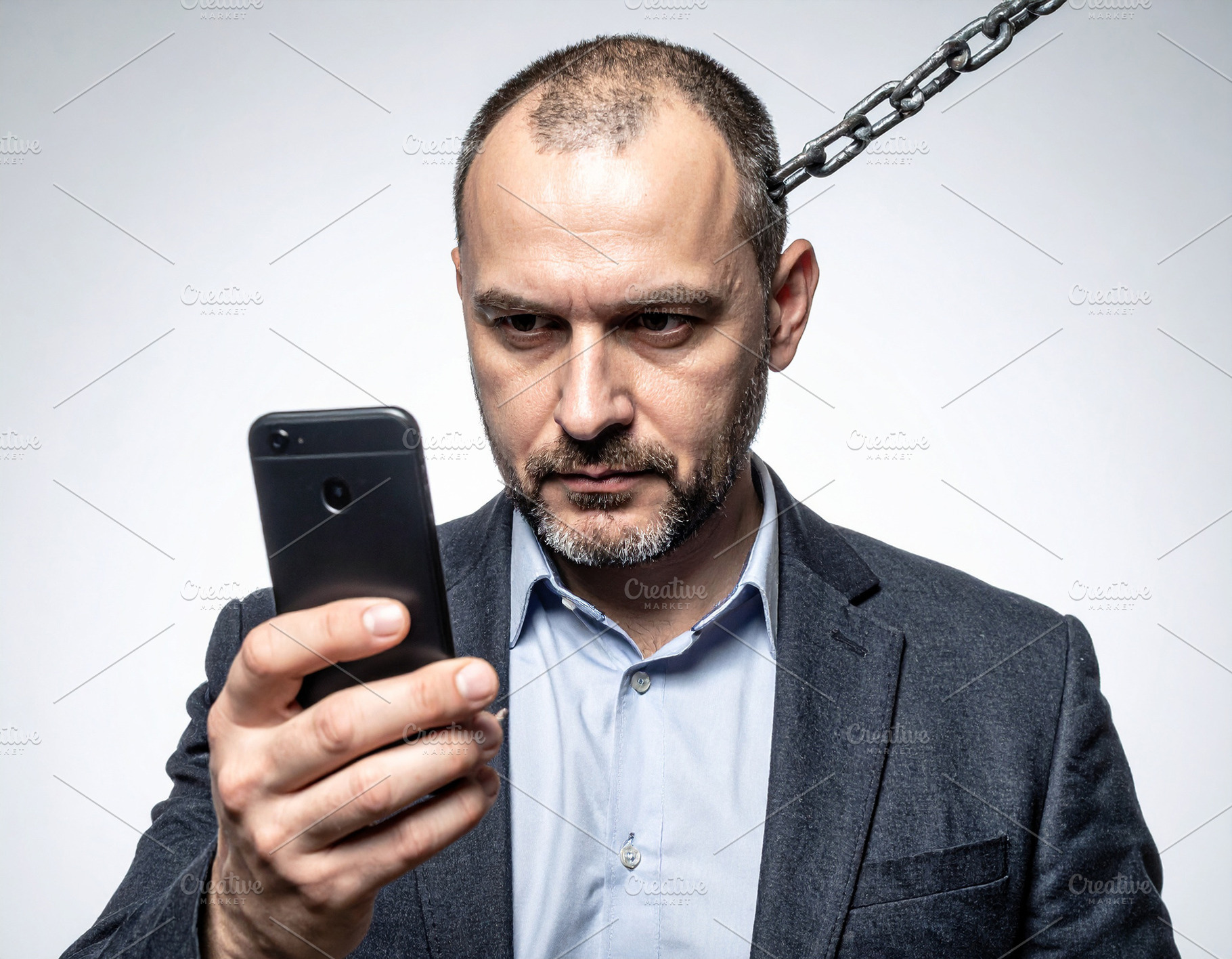 Man chained to smartphone, a Technology Photo by DanFLCreativo