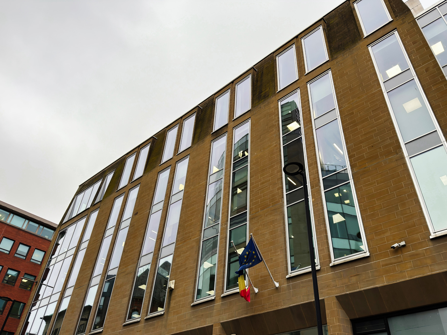 Modern brick building in Manchester with tall windows and EU flag and ...