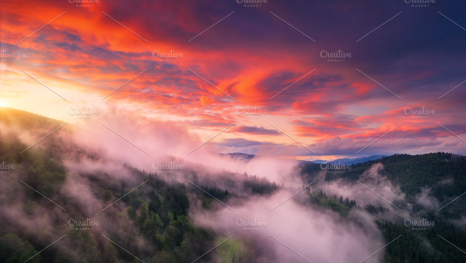 Mountains in low clouds at sunset in summer. Aerial view, a Nature Photo by den-belitsky