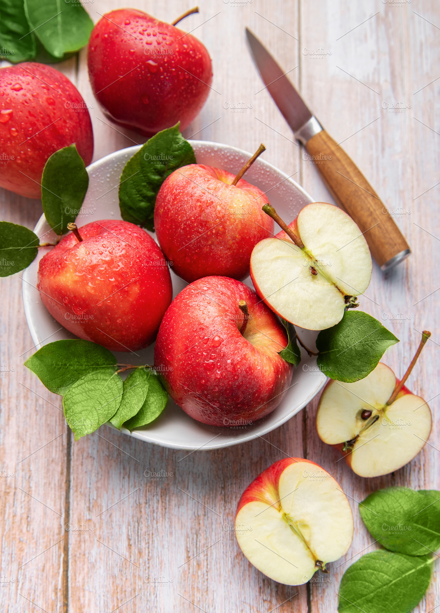 Fresh red apples with water drops and green leaves, a Food & Drink Photo by Olena Rudo