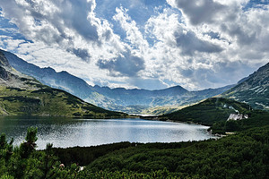Tranquil mountain lake near Zakopane Poland surrounded by green hills and drama, a Nature Photo by AS photostudio