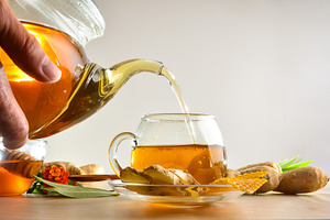 Person pouring a cup of ginger infusion from a teapot, a Food & Drink Photo by Davizro's Market