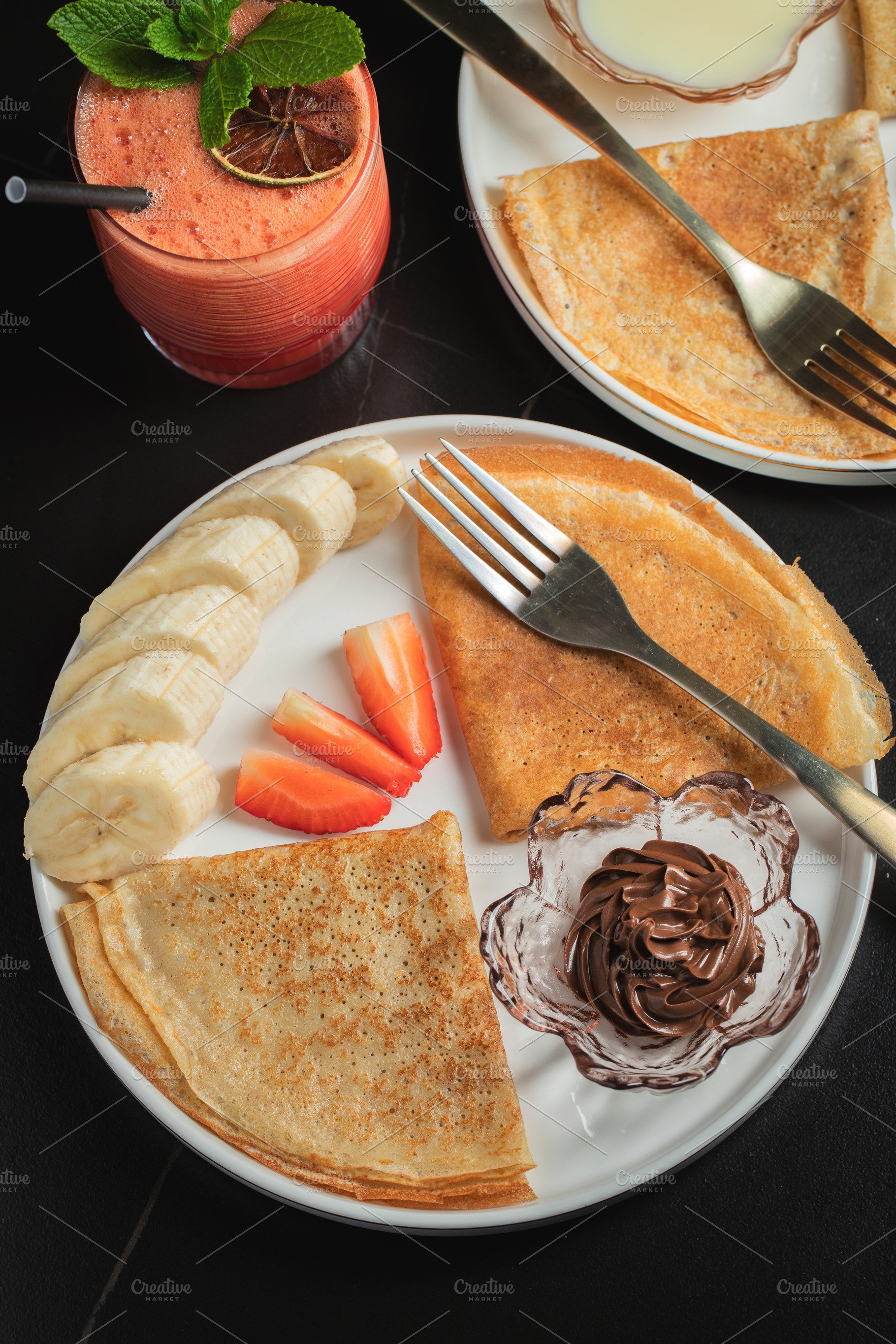 A plate of crepes filled with chocolate spread and topped with banana slices an, a Food & Drink Photo by Budarinphoto