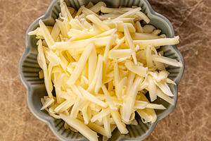 Shredded cheese waiting in a bowl, a Photo by Grafvision photography
