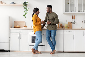 Young Black Married Couple Spending Time Together In Kitchen At Home, a Photo by Prostock-Studio