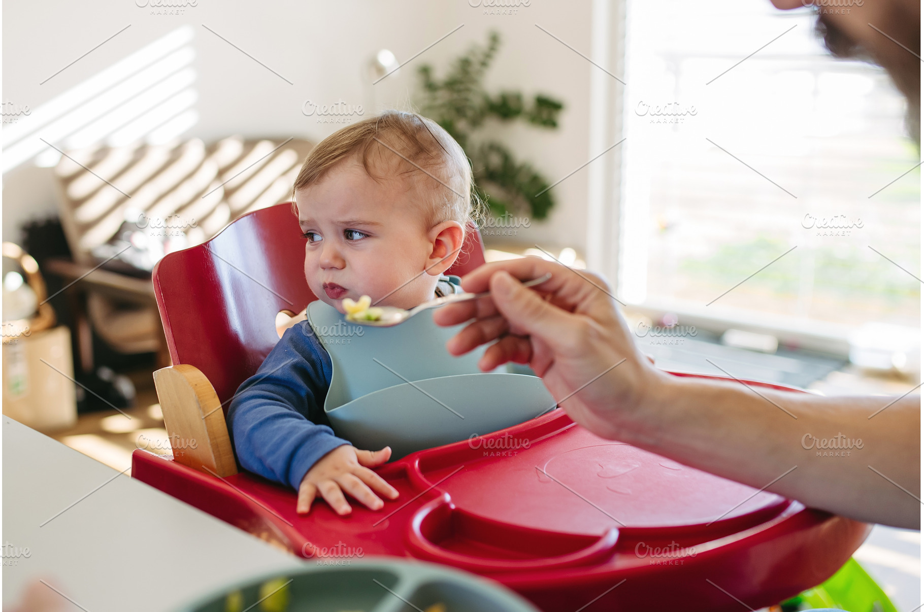 Caring father feeding toddler during, a Person Photo by HalfPoint