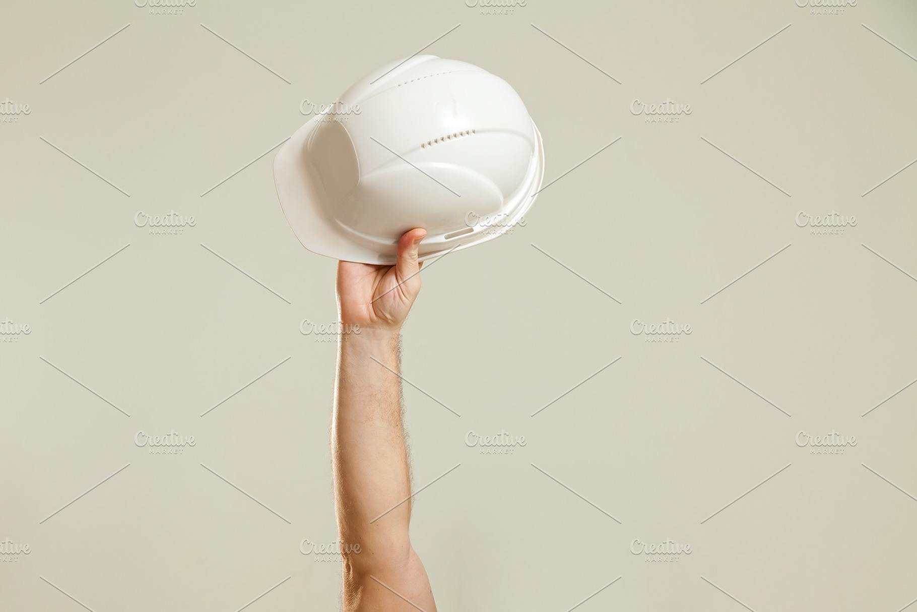 Hand holding a white construction helmet, a Person Photo by Photostock