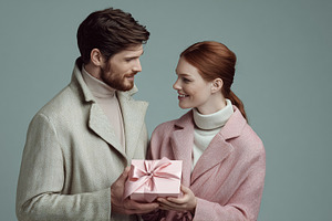 Young couple exchanging a Valentine's Day present, celebrating l, a Photo by Studio ANNA