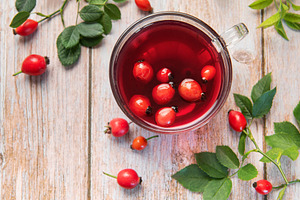 Rosehip tea brewing in glass cup on rustic wooden table, a Food & Drink Photo by Olena Rudo