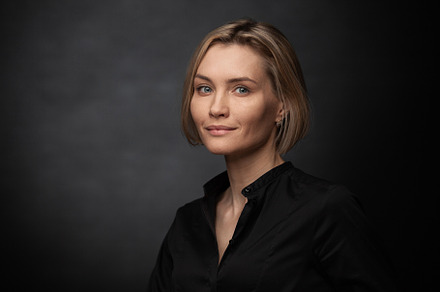 Beautiful middle-aged woman on a gray background in a black blouse.