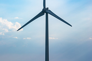 Tall wind turbine stands in a rural field under a partly cloudy sky, symbolizin, a Technology Photo by Ales Munt