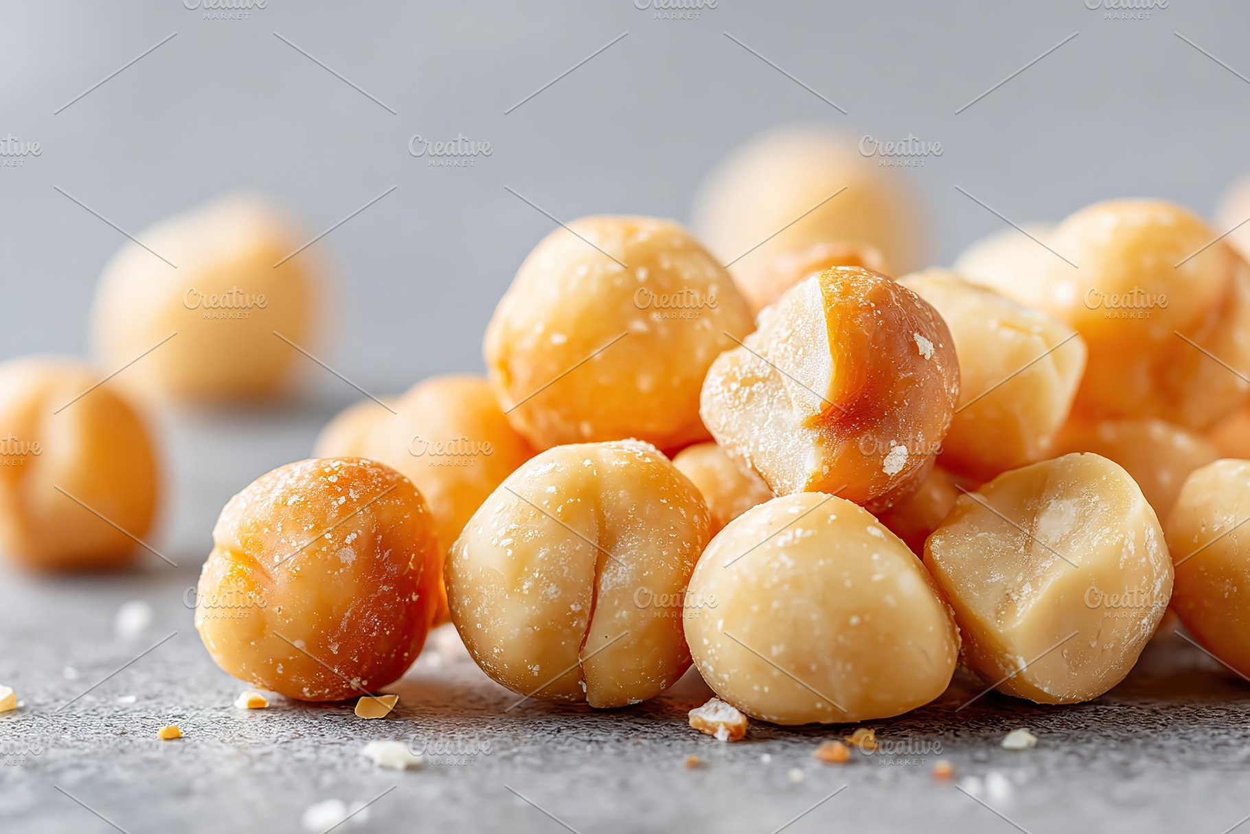 Crisp salted macadamia nuts arranged on a smooth gray surface with scattered pi, a Food & Drink Photo by AlyaAnd