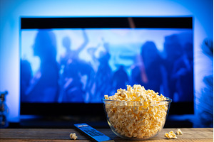 A glass bowl of popcorn and remote, a Technology Photo by Budarinphoto