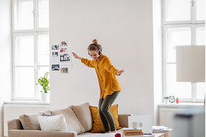 Young woman dancing on the couch, a Beauty & Fashion Photo by HalfPoint