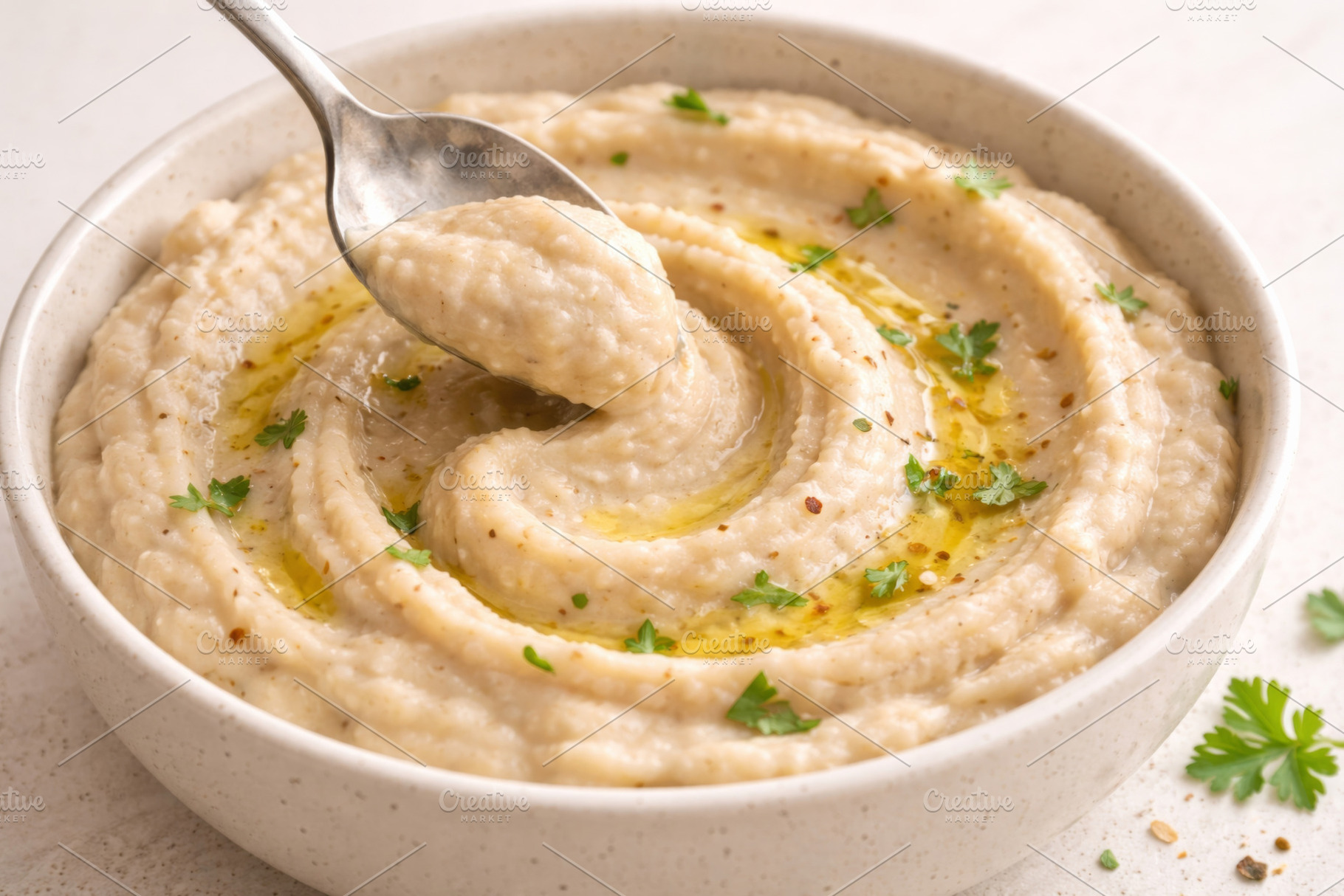 Bowl of creamy hummus swirl with oli, a Photo by Dvoevnore photos