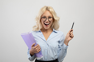 Overjoyed female entrepreneur in formal wear holding folder with documents and, a Photo by Prostock-Studio