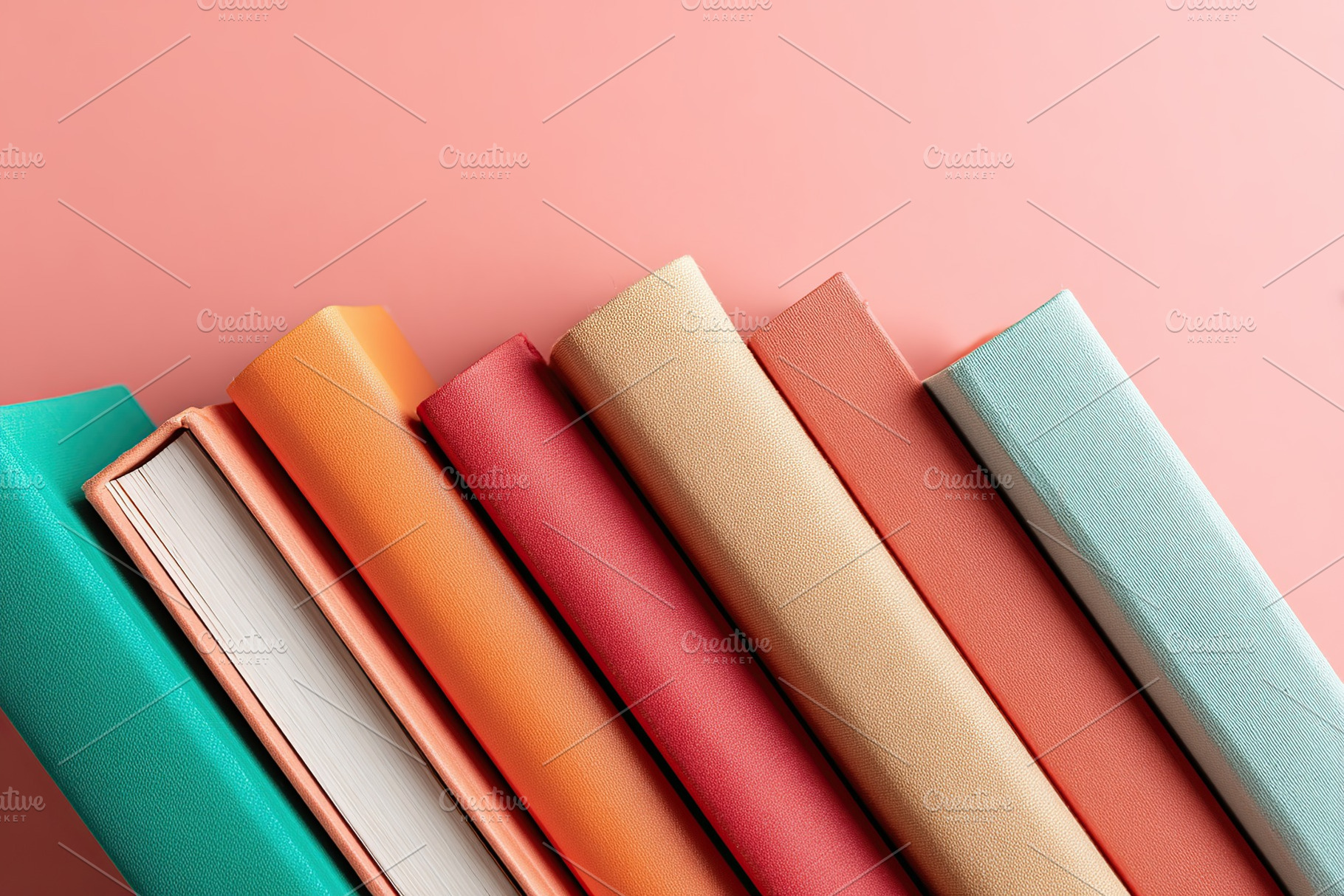 Flat lay of five closed books arranged in a colorful pattern on a pink backgrou, a Photo by AlyaAnd