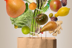 Levitating fresh vegetables and fruits flying out of a craft pap, a Food & Drink Photo by ndanko