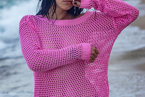 Young woman in a vibrant pink sweater and black bikini standing on a scenic bea, a Person Photo by Ales Munt