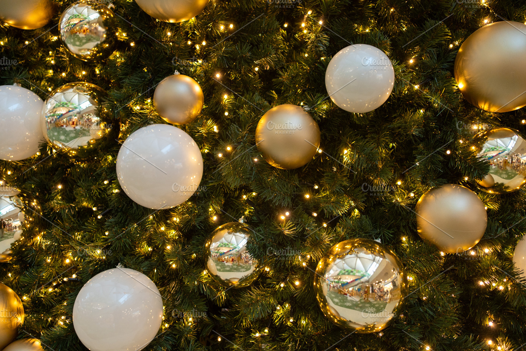 Closeup of Christmas tree decorated with shiny balls and fairy lights, a Photo by andreonegin market