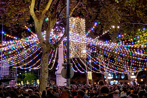 Crowd at a night festival with decorative lights, a Person Photo by DanFLCreativo