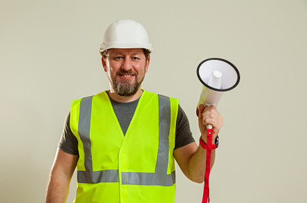 worker in a vest and white helmet, a Person Photo by Photostock