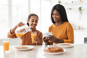 African Daughter Pouring Orange Juice In Glass For Mother Indoor, a Photo by Prostock-Studio (Thumbnail 1 of 4)