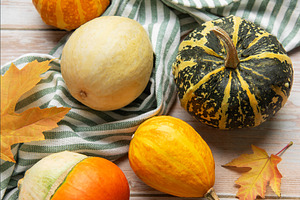 Autumn gourds pumpkins and fall leaves on wooden background, a Food & Drink Photo by Olena Rudo