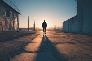 Man walking into sunset down empty s, a Photo by Pixeness Studio