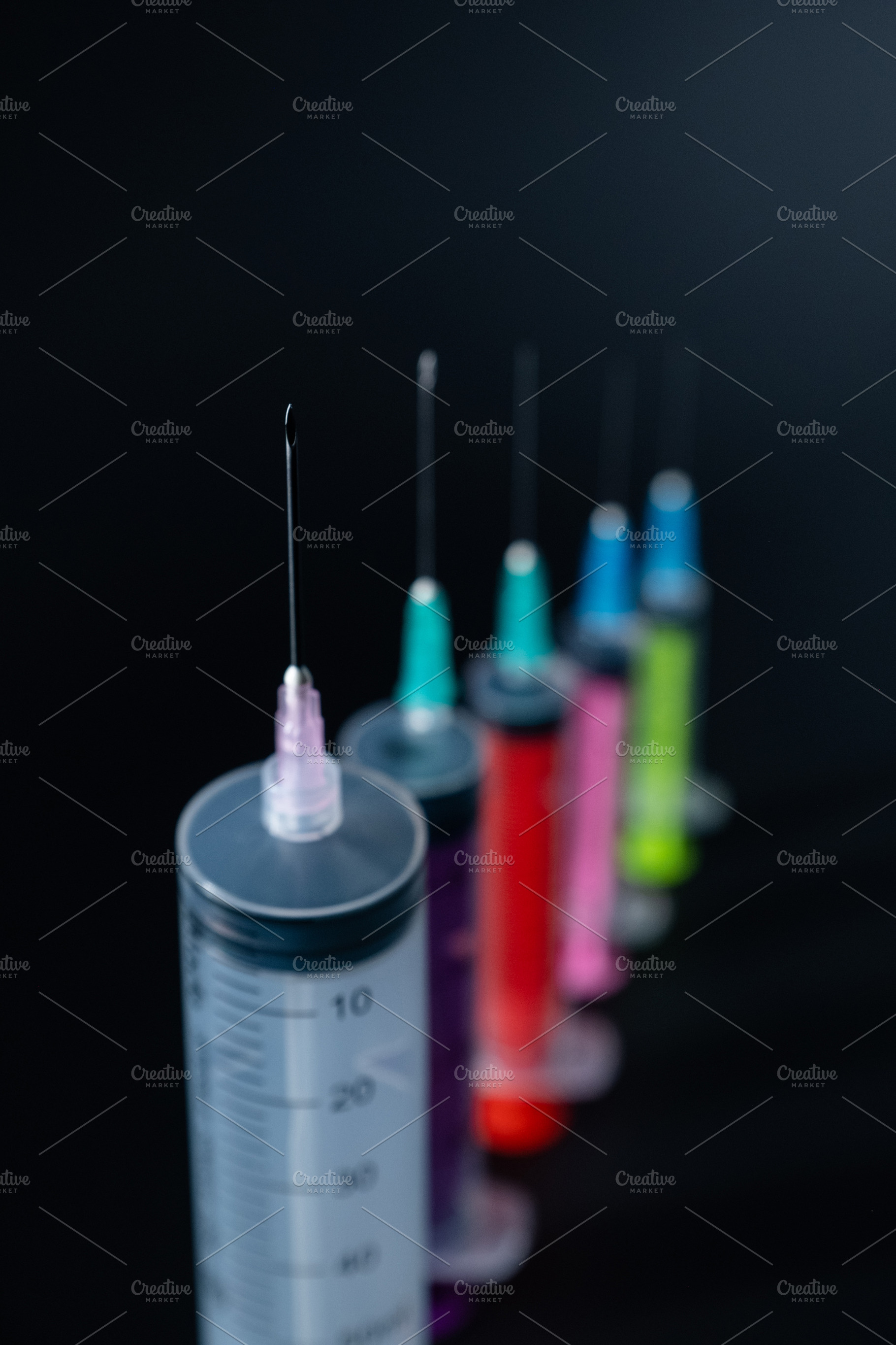 Focused Syringe Needle in a Row of Colorful Medical Supplies., a Health & Medical Photo by Rohan Photography