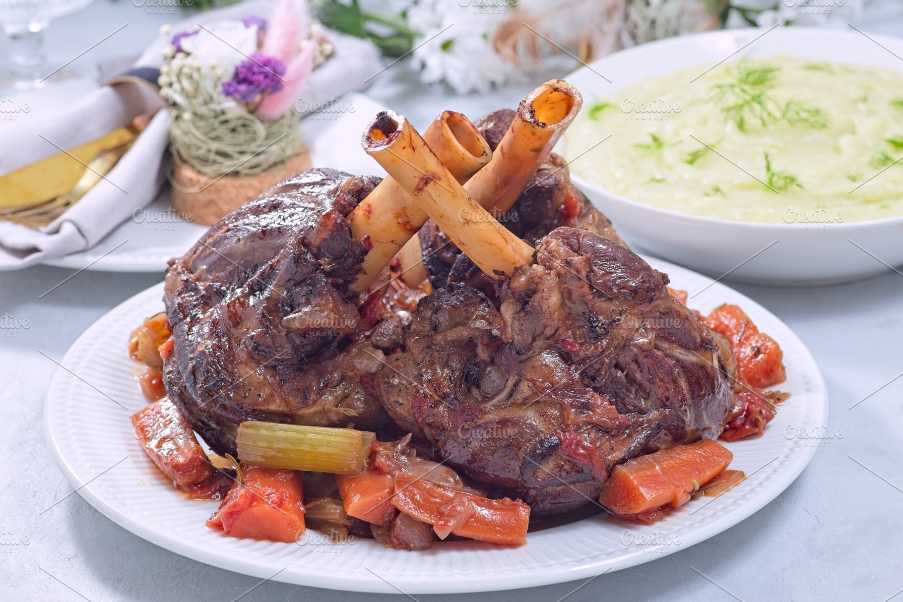 Delicious braised lamb shanks with vegetables served on a white plate, horizont, a Food & Drink Photo by iuliia_n