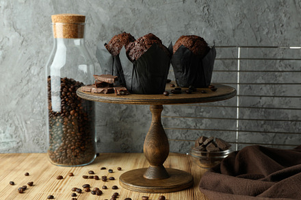 Concept of delicious food with chocolate muffins against gray ba, a Food & Drink Photo by AtlasStudio