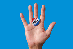 a vote badge on the open palm of a man